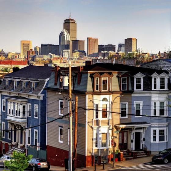 View of crowded Boston row homes with skyscrapers in background