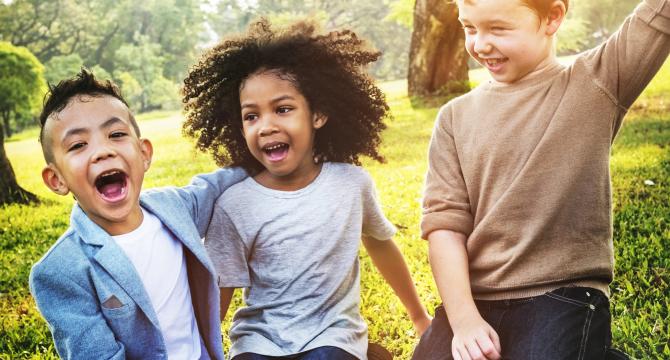 multi-racial kids in grassy field